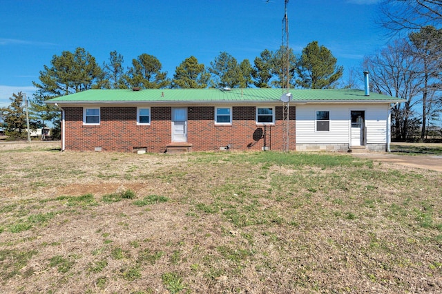 back of house featuring entry steps, metal roof, brick siding, crawl space, and a lawn