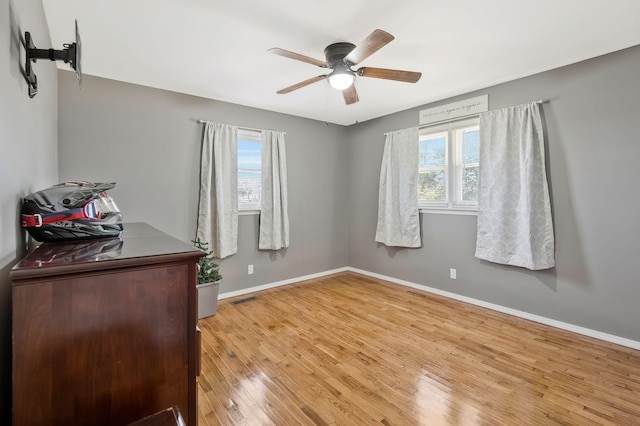 bedroom with light wood-style floors, baseboards, visible vents, and ceiling fan