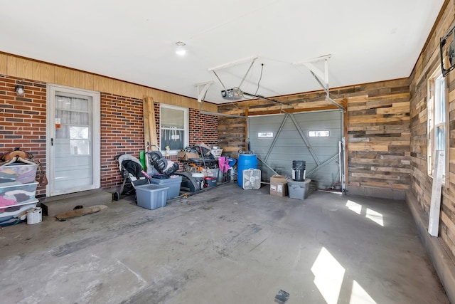 garage featuring a garage door opener and wood walls