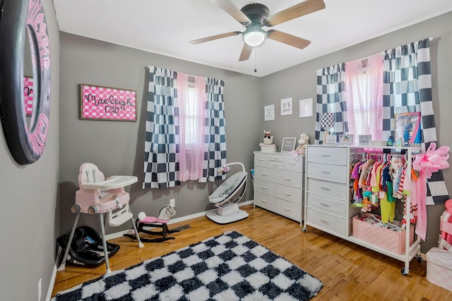 interior space featuring ceiling fan, baseboards, stainless steel refrigerator, and wood finished floors