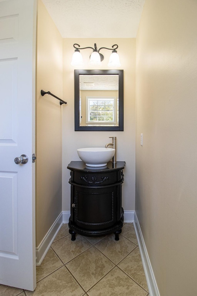 bathroom featuring tile patterned floors, vanity, and a textured ceiling