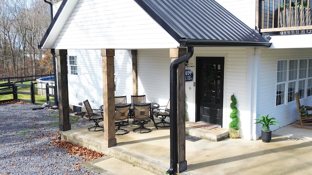 entrance to property featuring a balcony and a patio area