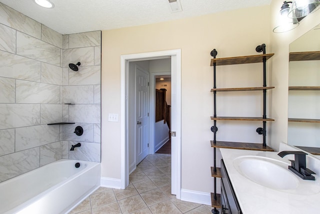 bathroom featuring tile patterned flooring, vanity, tiled shower / bath, and a textured ceiling