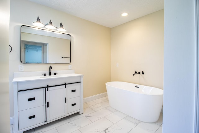 bathroom featuring a bath, vanity, and a textured ceiling