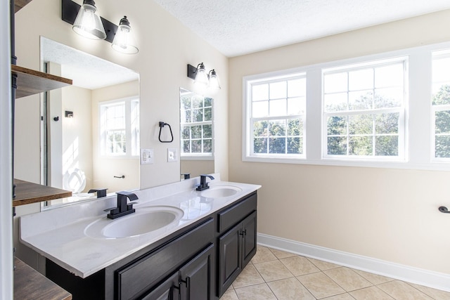 bathroom featuring tile patterned floors, vanity, and a textured ceiling