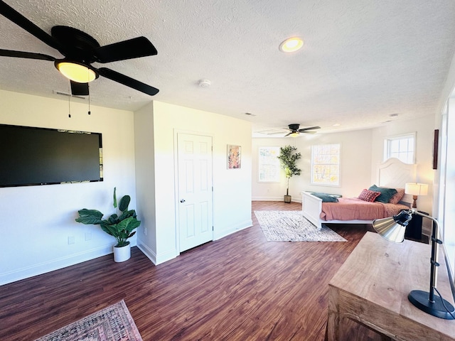 bedroom with a textured ceiling, ceiling fan, and dark hardwood / wood-style floors