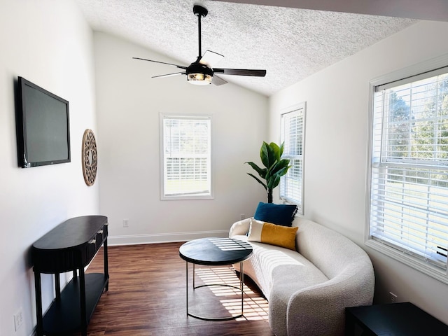 sitting room featuring ceiling fan, dark hardwood / wood-style flooring, lofted ceiling, and a textured ceiling