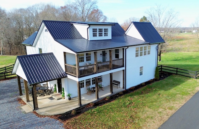 back of house with a lawn, a balcony, and a patio