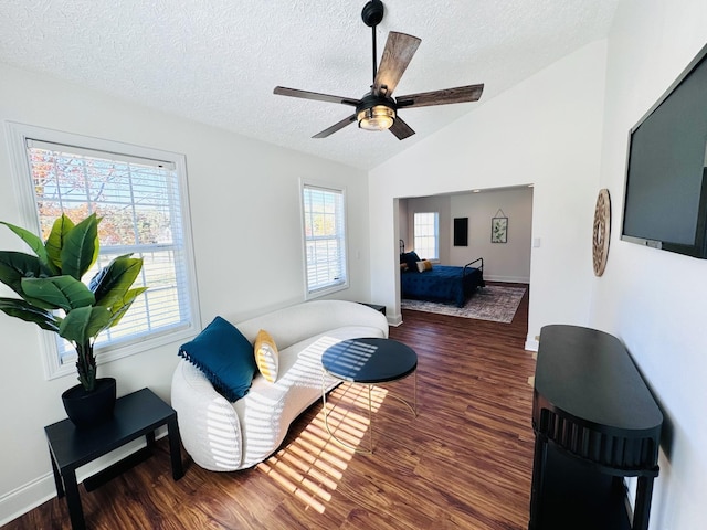 living room featuring vaulted ceiling, ceiling fan, a healthy amount of sunlight, and dark hardwood / wood-style floors