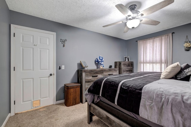 bedroom featuring ceiling fan, light colored carpet, and a textured ceiling