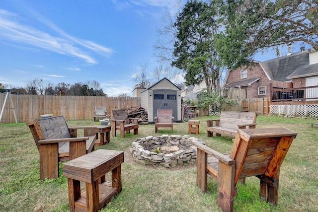 view of yard with a storage unit, an outdoor fire pit, and a wooden deck