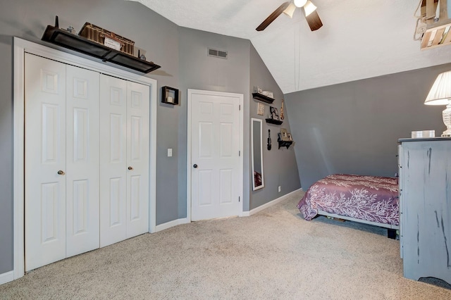 bedroom featuring ceiling fan, a closet, carpet, and vaulted ceiling