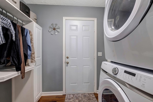 laundry room with cabinets, a textured ceiling, stacked washing maching and dryer, and dark hardwood / wood-style floors