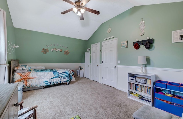 bedroom featuring ceiling fan, multiple closets, carpet floors, and lofted ceiling