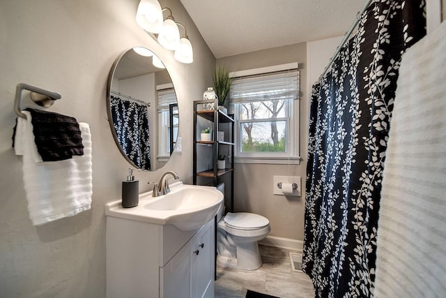 bathroom featuring a textured ceiling, vanity, and toilet