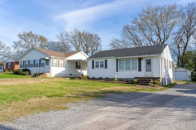 ranch-style house featuring a garage, an outbuilding, and a front yard