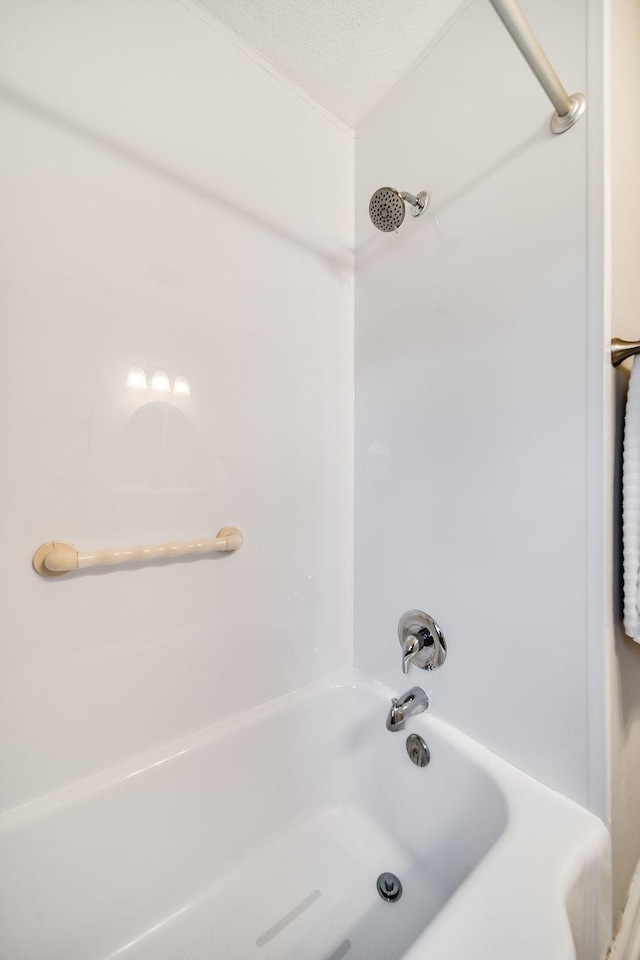 bathroom featuring shower / washtub combination and a textured ceiling