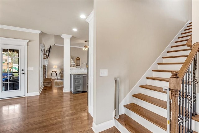 staircase with hardwood / wood-style floors, decorative columns, ceiling fan, and crown molding