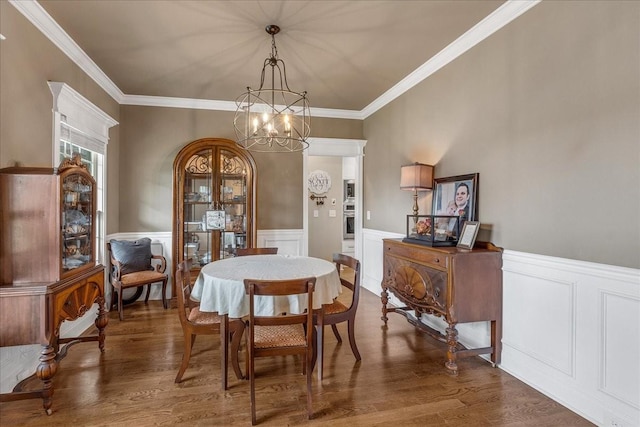 dining room featuring a chandelier, dark hardwood / wood-style floors, and crown molding