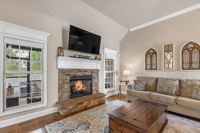 living room with hardwood / wood-style floors, lofted ceiling, a fireplace, and ornamental molding