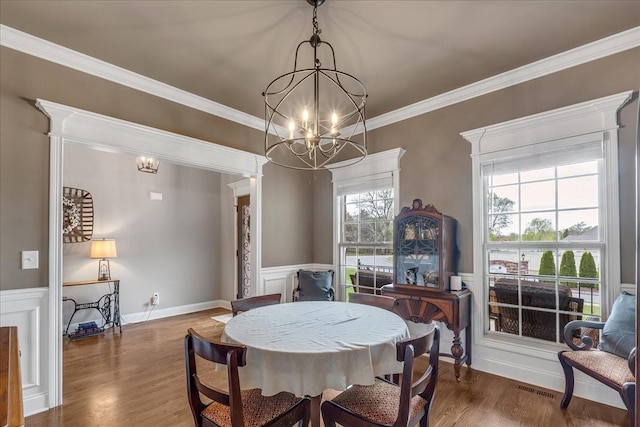 dining space with ornamental molding, dark wood-type flooring, and a chandelier