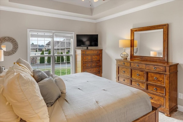 carpeted bedroom featuring ornamental molding and a tray ceiling