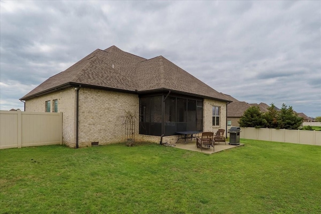 back of house with a yard, a patio area, and a sunroom