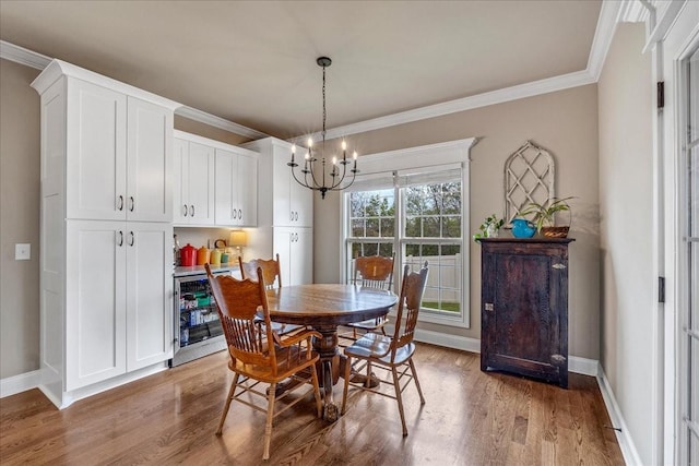 dining area featuring a chandelier, hardwood / wood-style floors, beverage cooler, and ornamental molding