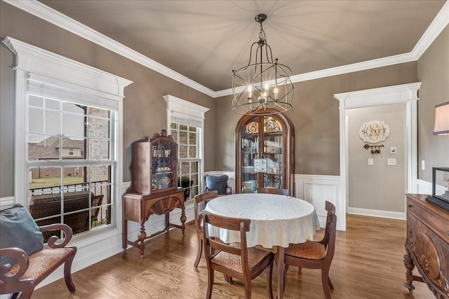 dining space with crown molding, hardwood / wood-style floors, and a chandelier