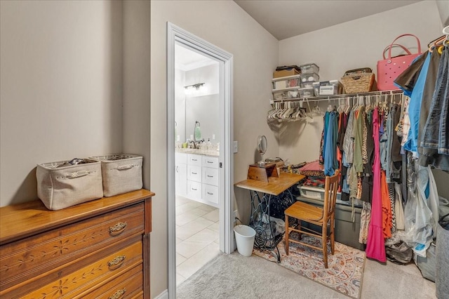 walk in closet with light tile patterned floors and sink