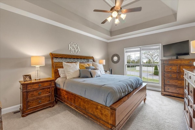 bedroom featuring ceiling fan, a raised ceiling, light colored carpet, and crown molding