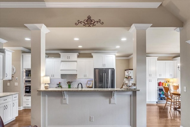 kitchen featuring light stone counters, white cabinets, and stainless steel appliances