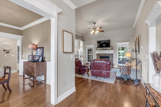 living room featuring hardwood / wood-style floors, ceiling fan, ornamental molding, and a fireplace