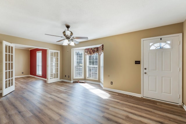 foyer entrance with french doors, ceiling fan, a textured ceiling, and hardwood / wood-style flooring