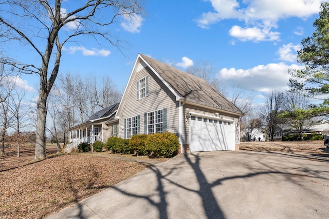 view of property exterior with a garage and covered porch