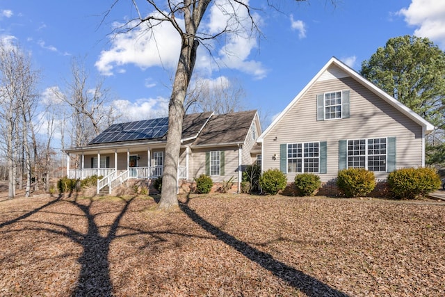 view of front facade featuring solar panels and covered porch