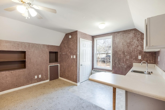 interior space featuring vaulted ceiling, sink, light colored carpet, and ceiling fan