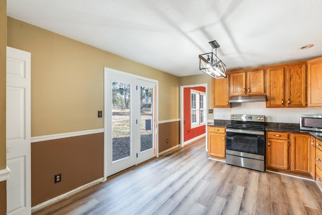 kitchen featuring pendant lighting, tasteful backsplash, stainless steel appliances, and light wood-type flooring