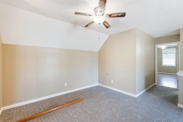 additional living space featuring vaulted ceiling, carpet flooring, ceiling fan, and a textured ceiling