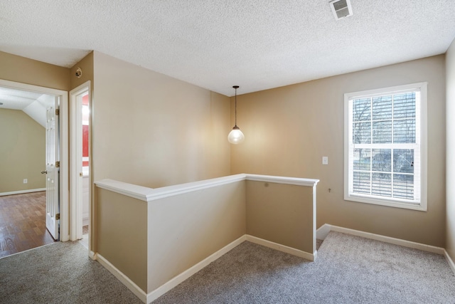 hallway featuring a textured ceiling and carpet