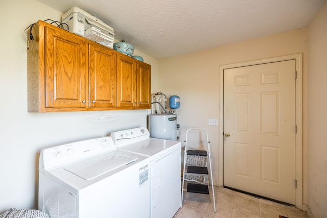 laundry room with electric water heater, washer and clothes dryer, cabinets, and a textured ceiling