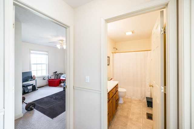 full bathroom with ceiling fan, vanity, shower / bath combo, and toilet