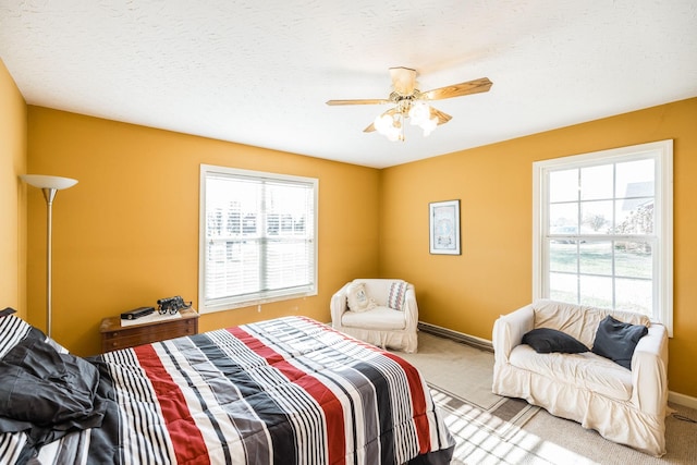 carpeted bedroom featuring ceiling fan and a textured ceiling