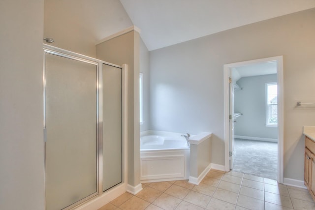 bathroom with tile patterned flooring, vanity, and plus walk in shower