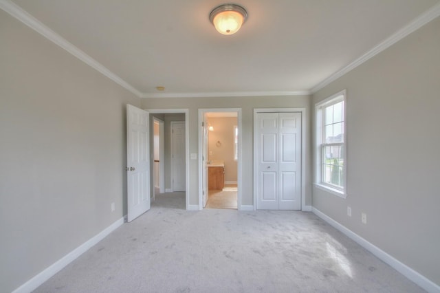 unfurnished bedroom featuring ensuite bathroom, ornamental molding, and light carpet