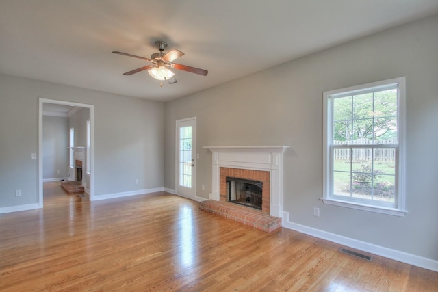 unfurnished living room with a fireplace, light hardwood / wood-style floors, and plenty of natural light