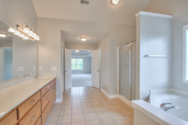 bathroom featuring plus walk in shower, vanity, and tile patterned floors