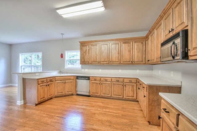 kitchen with dishwasher, sink, hanging light fixtures, light hardwood / wood-style flooring, and kitchen peninsula