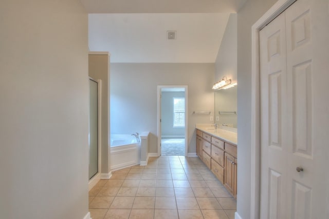 bathroom with tile patterned flooring, lofted ceiling, vanity, and plus walk in shower