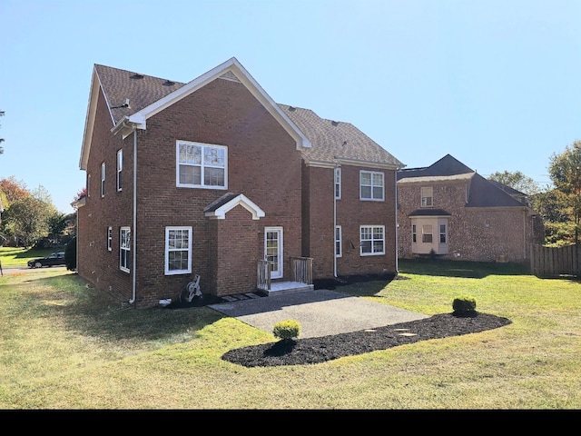 rear view of property featuring a lawn